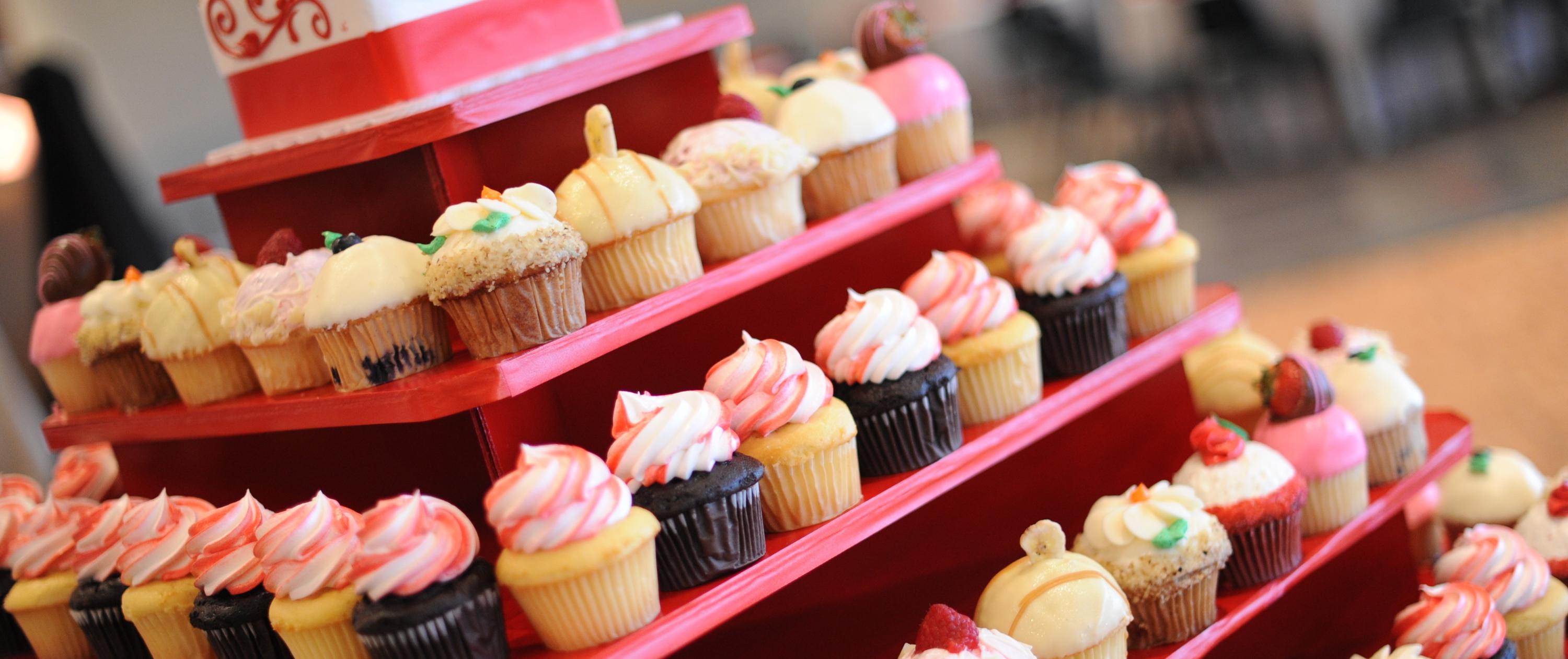 Pink tiered tray with an assortment of cupcakes