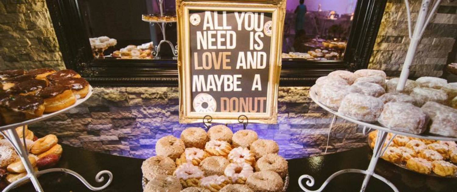 "All you need is love and maybe a donut" sign on donut table