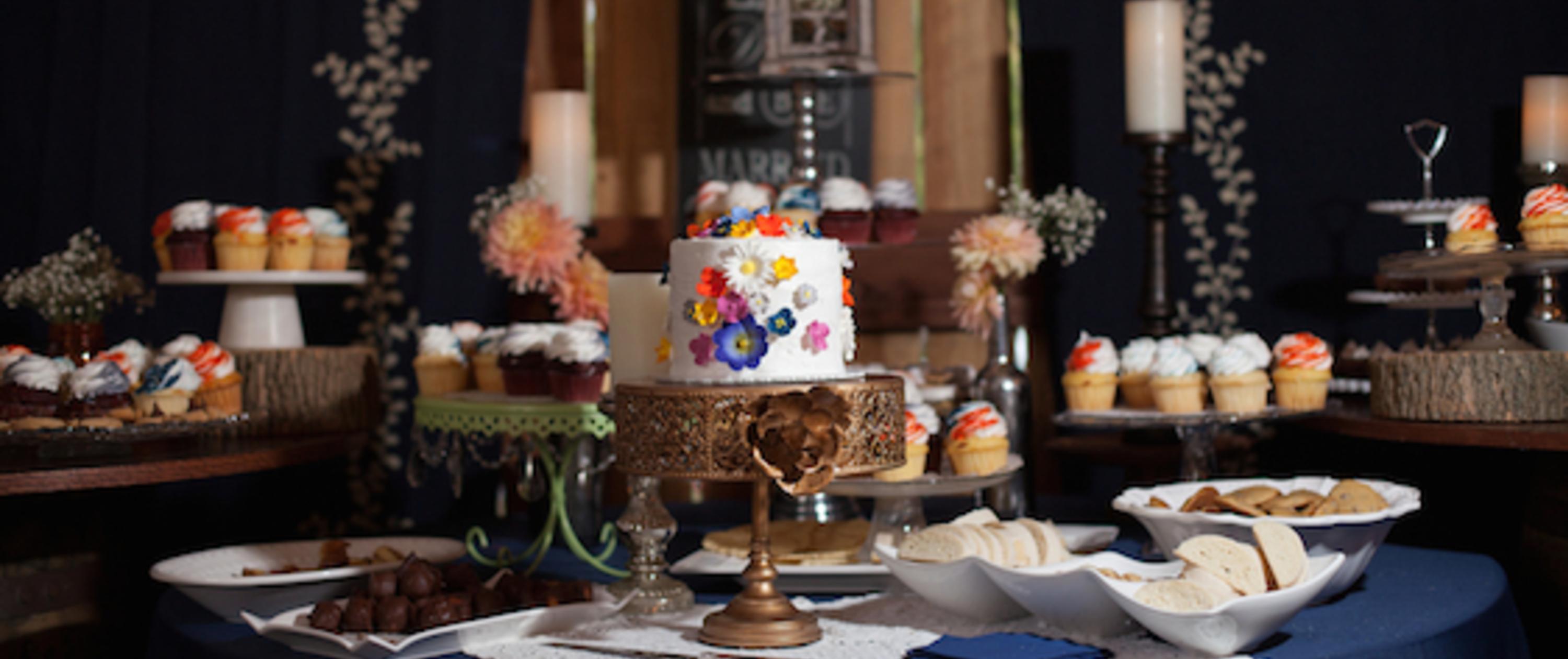 Fancy table setting with a miniature wedding cake and cupcakes