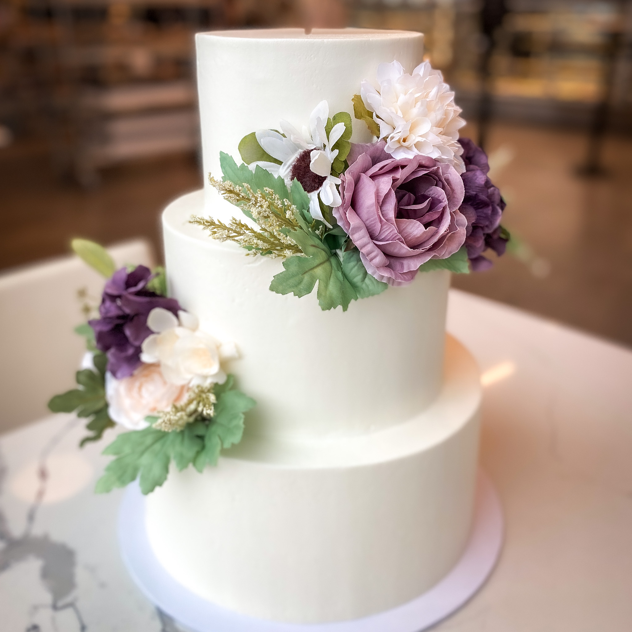 https://oakmontbakery.com/wp-content/uploads/2020/06/Smooth-Iced-with-Silk-Flowers.jpg