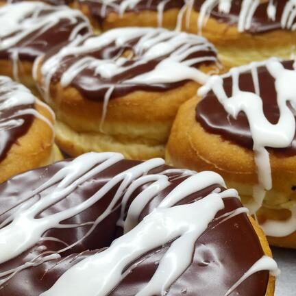 Chocolate glazed donuts with white swirled icing